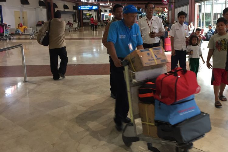 Petugas airport helper sedang membawa barang penumpang dengan troli di Terminal 2 Bandara Soekarno-Hatta, Tangerang, Selasa (10/10/2017). 