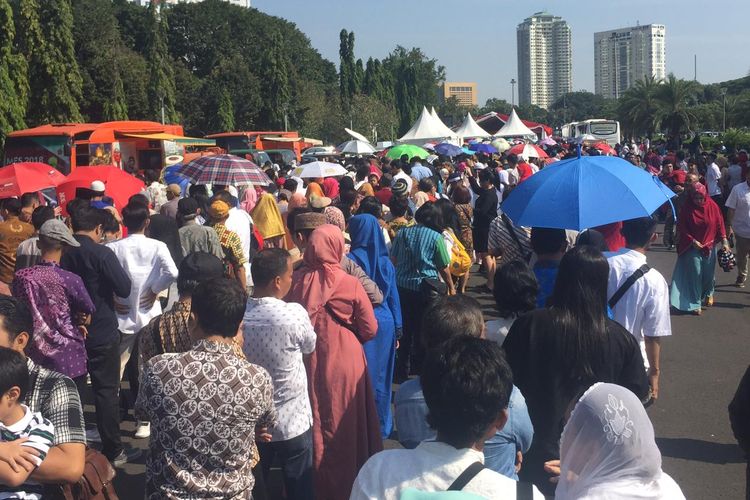 Masyarakat mengantre di pelataran Monas, Jakarta, Rabu (5/6/2019), menunggu giliran masuk ke Istana Negara guna bersilaturahmi dengan Presiden Joko Widodo pada lebaran hari pertama.