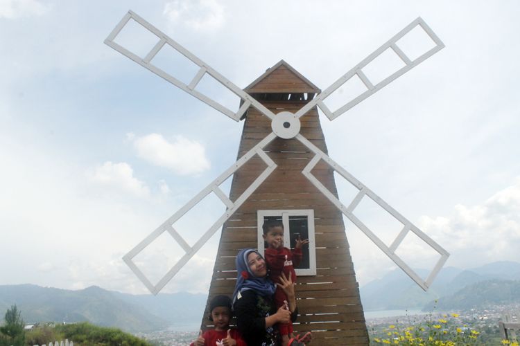 Wisatawan berfoto di spot kincir angin di obyek wisata Buntul Rintis, di  Desa Tensaren, Kecamatan Bebesen, Kabupaten Aceh Tengah, Aceh.