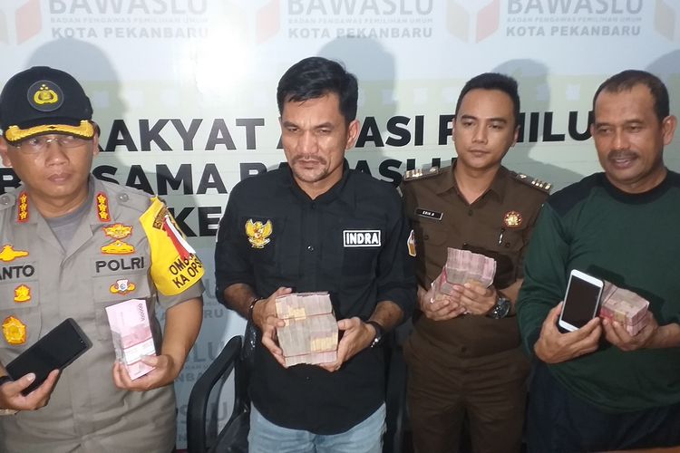 Bawaslu dan Polresta Pekanbaru melihatkan barang bukti uang yang diamankan dari empat orang terduga pelaku politik uang, saat konferensi pers, Selasa (16/4/2019). 
