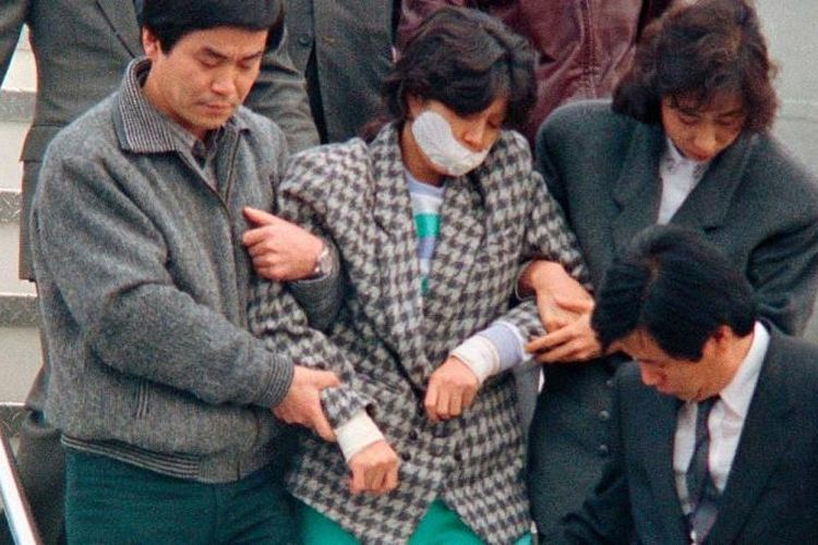 Kim Hyon Hui digiring para agen Korea Selatan saat tiba di Seoul pada 15 Desember 1987 setelah diekstradisi dari Bahrain.