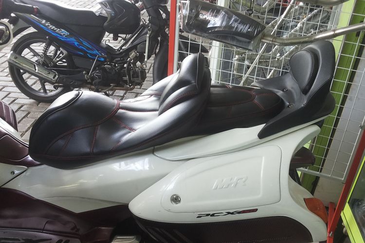 Jok variasi yang terpasang di salah satu unit Honda PCX model lama di pusat aksesori motor di kawasan Otista, Jakarta Timur, Selasa (16/1/2017).