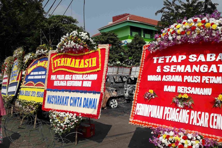 Sejumlah karangan bunga kiriman warga ditempatkan di depan Markas Brimob, Petamburan, Jakarta Barat.  Sejumlah kendaraan di depan Markas Brimob itu dirusak massa dalam kerusuhan pada 21 hingga 22 Mei ini.