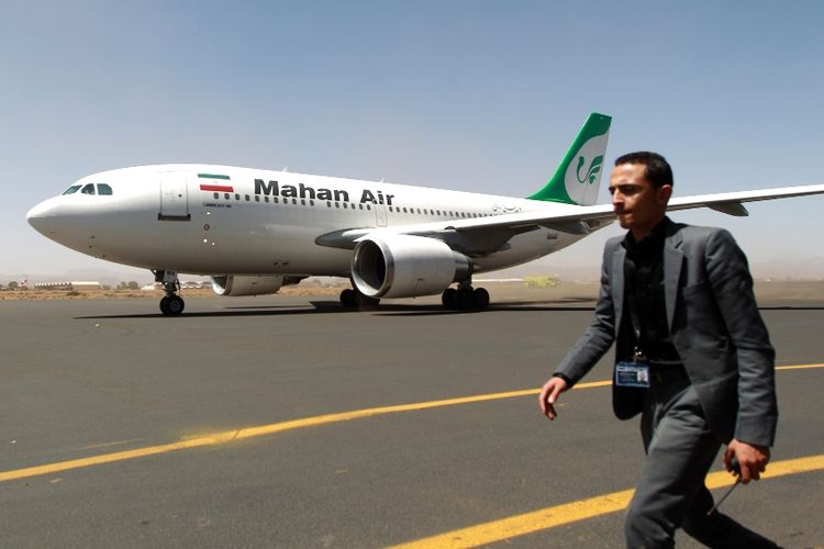 Seorang staf Bandara Internasional Sanaa di Yaman, berjalan melintasi sebuah pesawat milik maskapai penerbangan Iran, Mahan Air.