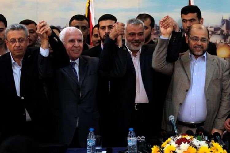 PM Hamas, Ismail Haniya (tengah) diapit delegasi PLO dari Tepi Barat, saat mengumumkan kesepakatan Hamas dan Fatah membentuk pemerintahan bersama sebelum menggelar pemilu dalam tujuh bulan.