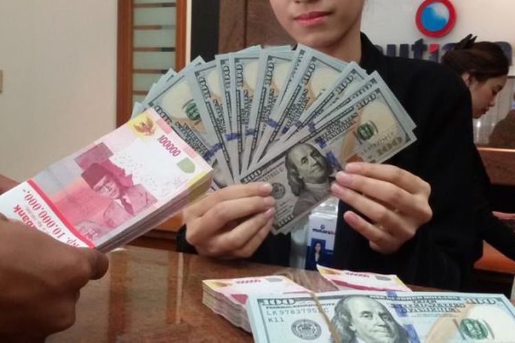 Ilustrasi. Petugas teller melayani penukaran mata uang dolar AS dengan rupiah di sebuah bank.  