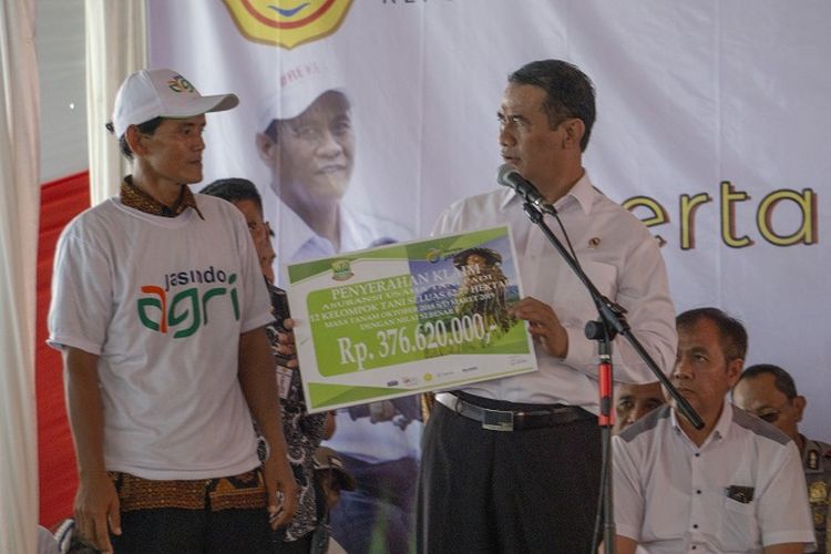 Menteri Pertanian Andi Amran Sulaiman memberikan bantuan Asuransi Usaha Tani Padi (AUTP) kepada petani