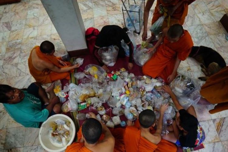 Para biksu sedang memilah makanan yang disumbangkan warga Thailand. Para biksu dilarang makan setelah tengah hari, sebagai gantinya mereka banyak mengonsumsi minuman manis yang membuat tidak sehat.
