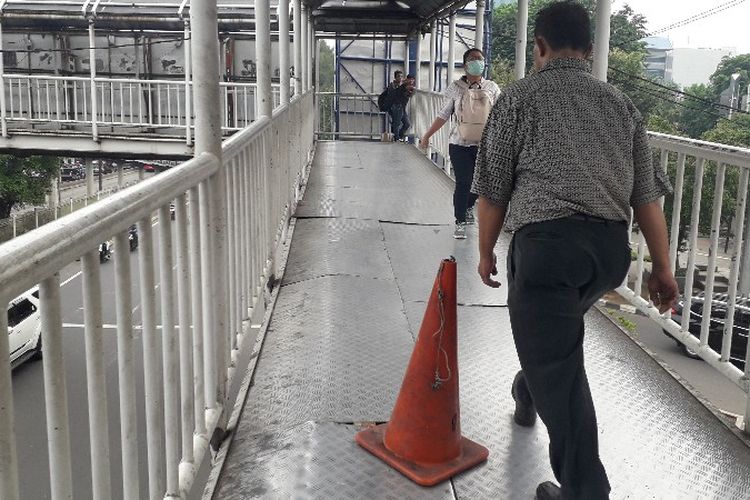 Jembatan Penyebrangan Orang (JPO) Grogol, Jakarta Barat dipasangkan tanda traffic cone pada bagian pelat brodes yang terbuka dan bautnya terlepas pada Senin (3/12/2018).