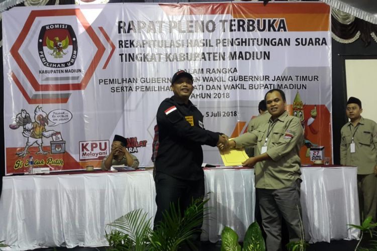 Ketua KPU Kabupaten Madiun, Wahyudi menyerahkan rekapitulasi hasil penghitungan suara Pilkada Kabupaten Madiun 2018 kepada Ketua Panwaslu, Agus Setiawan, Kamis ( 5/7/2018) sore. 