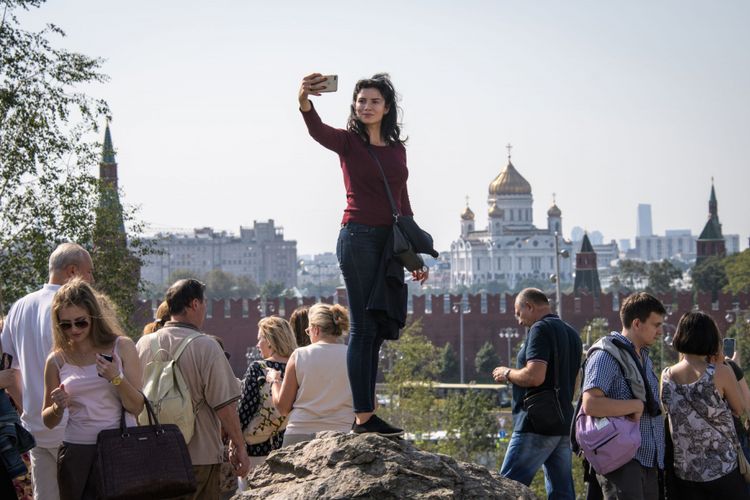 Seorang wanita berfoto selfie di Taman Zaryadye dengan latar belakang kompleks Kremlin di Kota Moskwa tengah, Rusia, 12 September 2017.