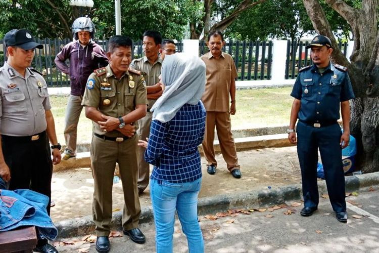 Kepala Satuan Polisi Pamong Praja dan Wilayatul Hisbah, Kota Lhokseumawe, M Irsyadi, menasehati remaja yang mengenakan pakaian ketat dalam razia busana di Kota Lhokseumawe, Selasa (24/4/2018)