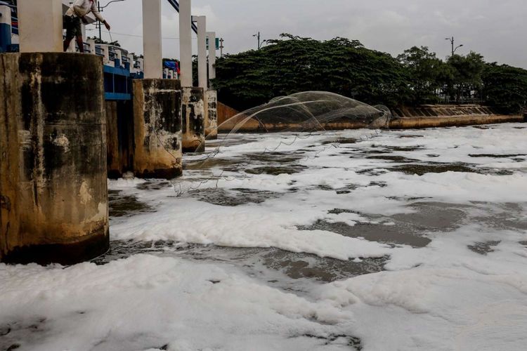 Warga menebar jala saat memancing di sungai berbusa di Perairan Kanal Banjir Timur (KBT), kawasan Marunda, Jakarta Utara, Sabtu (24/3/2018). Busa yang memenuhi KBT selepas Pintu Air Weir 3 Marunda ini akibat limbah rumah tangga.