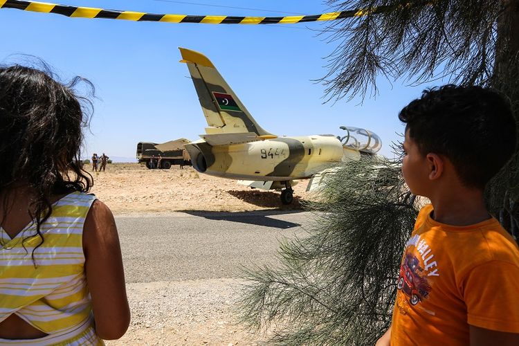 Anak-anak melihat pesawat tempur Libya milik pasukan pro-Haftar, yang mendarat darurat jalanan di Tunisia, Senin (22/7/2019).
