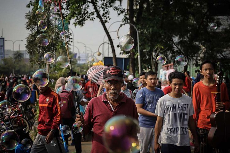 Pedagang memainkan balon sabun yang djualnya saat hari bebas kendaraan atau car free day di Jalan Ahmad Yani, Kota Bekasi, Jawa Barat, Minggu (30/9/2018). Selain untuk berolahraga, car free day yang rutin digelar tiap Minggu pagi tersebut juga menjadi alternatif hiburan bagi warga untuk rekreasi, kegiatan sosial hingga kumpul komunitas.