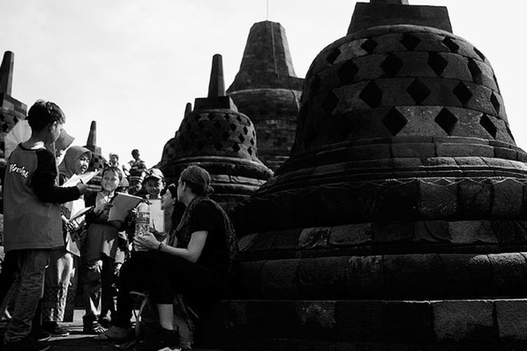 Murid Madrasah Ibtidaiyah Negeri 1 Jombang berlatih berbicara menggunakan bahasa Inggris dengan wisatawan asing di obyek wisata Candi Borobudur, Magelang, Jawa Tengah, Minggu (16/9/2018). Mereka melatih kemampuan berkomunikasi menggunakan bahasa asing. 