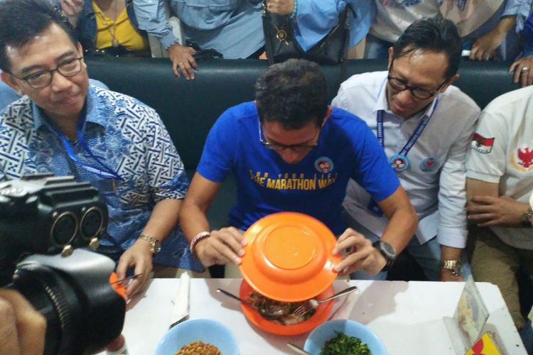 Calon Wakil Presiden RI nomor urut 02 Sandiaga Salahudin Uno mencoba membalikkan sepiring bubur ayam anti tumpah di Kedai Bubur Mang Haji Oyo, Jalan Sulanjana, Kota Bandung, Rabu (14/11/2018)