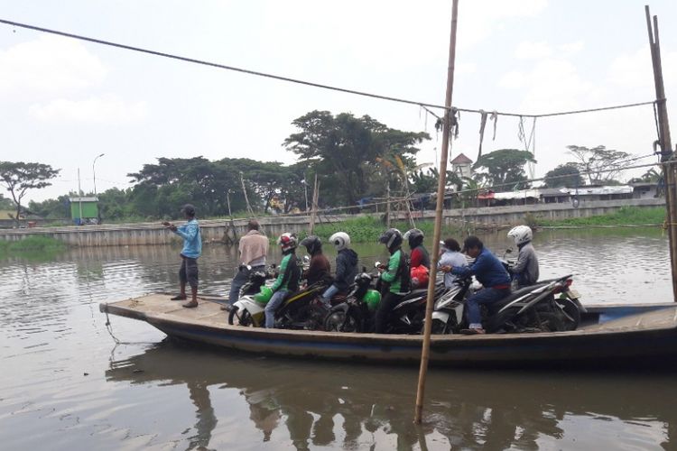 Sejumlah pengendara sepeda motor menggunakan perahu eretan yang beroperasi di Kali Cagak, Jakarta Utara, Kamis (15/3/2018), untuk menyeberangi sungai.