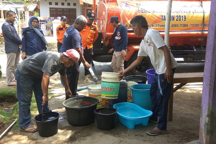 Petugas BPBD Kabupaten Ciamis mengisi air ke ember milik warga di Desa Kalijaya, Kecamatan Banjaranyar, Kabupaten Ciamis, Kamis sore (29/8/2019).