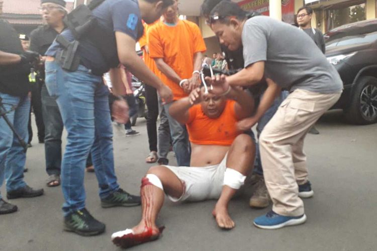 Pelaku penjambretan nenek gendong anak tidak kuat menahan sakit saat dibawa ke mobil patroli.(KOMPAS.com/ VERRYANA NOVITA NINGRUM)