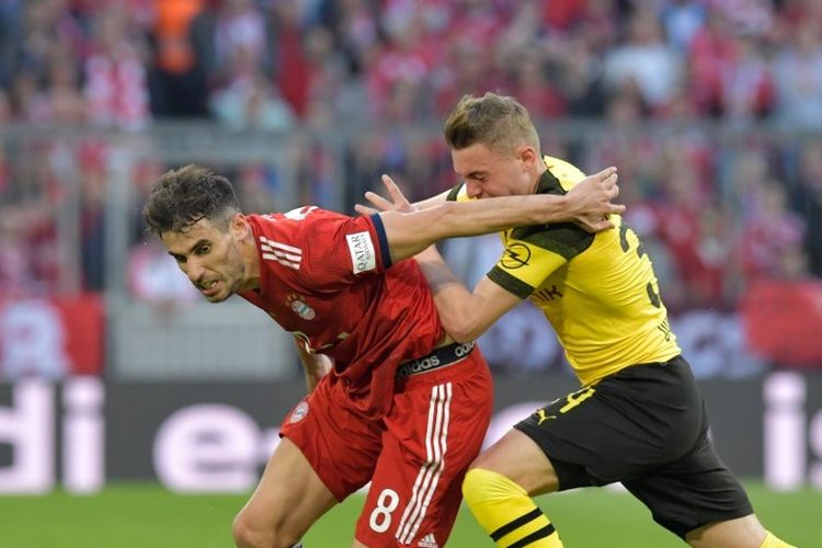 Javi Martinez menghalang-halangi Jacob Bruun pada pertandingan bertajuk Der Klassiker, Bayern Muenchen vs Borussia Dortmund, dalam lanjutan Liga Jerman di Allianz Arena, 6 April 2019. 