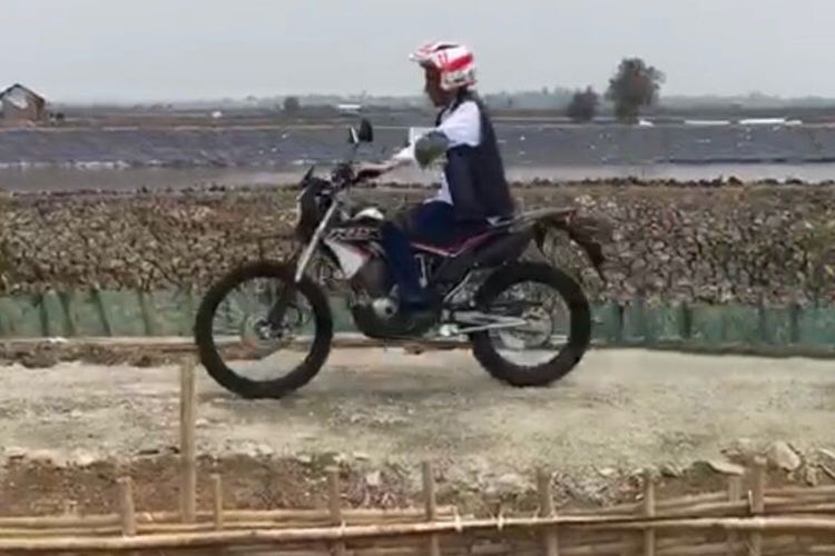 Presiden Joko Widodo mengendarai motor trail saat meninjau lokasi tambak udang dan ikan bandeng sebagai bagian dari program perhutanan sosial di Kecamatan Muara Gembong, Bekasi, Rabu (1/11/2017).