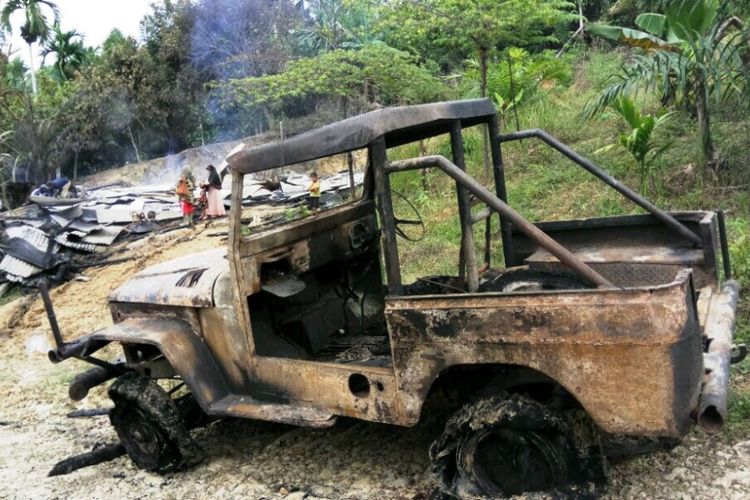 Warga melihat puing-puing rumah dan mobil yang terbakar di Desa Cot Girek, Kecamatan Cot Girek, Aceh Utara, Minggu (10/12/2017)