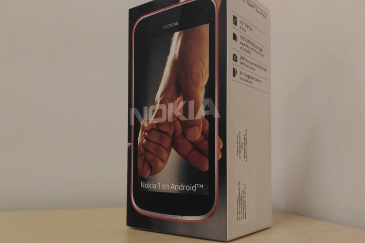 Kotak kemasan Nokia 1 dengan logo tangan anak kecil mengagndek jemari orang dewasa