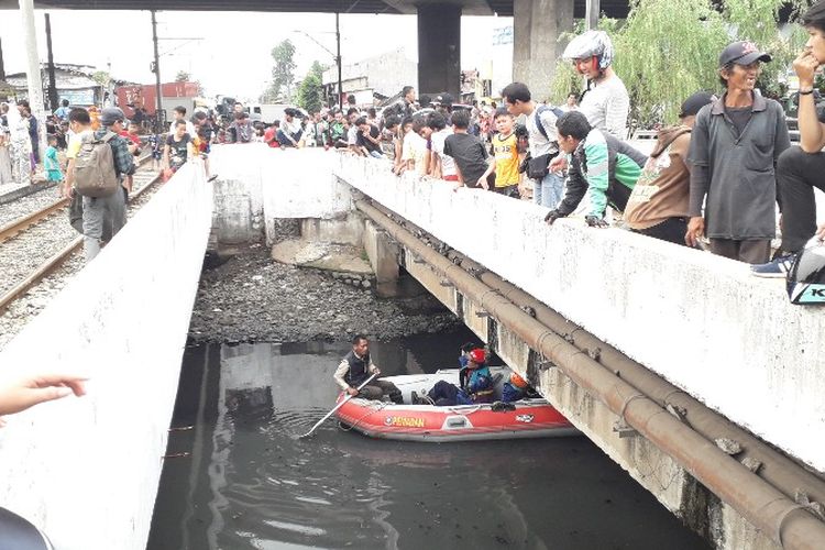 Sejumlah warga menyaksikan pencarian tiga ekor buaya yang ada si Kali Grogol, Jakarta Barat pada Kamis (28/6/2018).