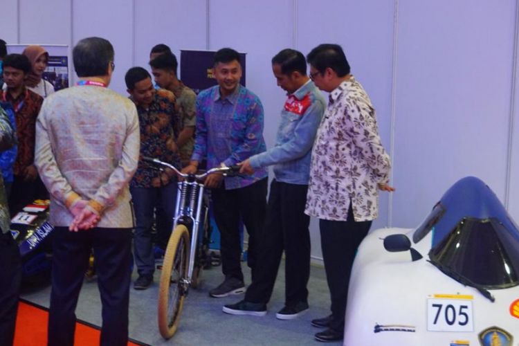 Jokowi mengamati sepeda listrik buatan mahasiswa di IIMS 2018.