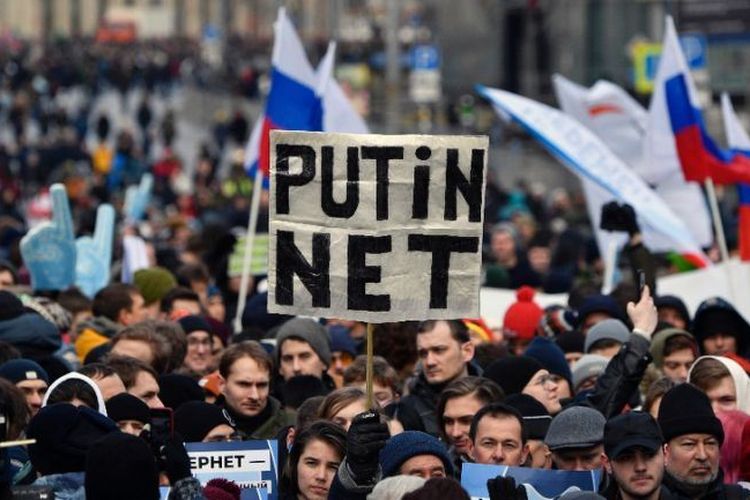 Demonstran memegang spanduk bertuliskan Putin Net selama aksi unjuk rasa di Moskow tengah, pada Minggu (10/3/2019), untuk menuntut kebebasan internet di Rusia.