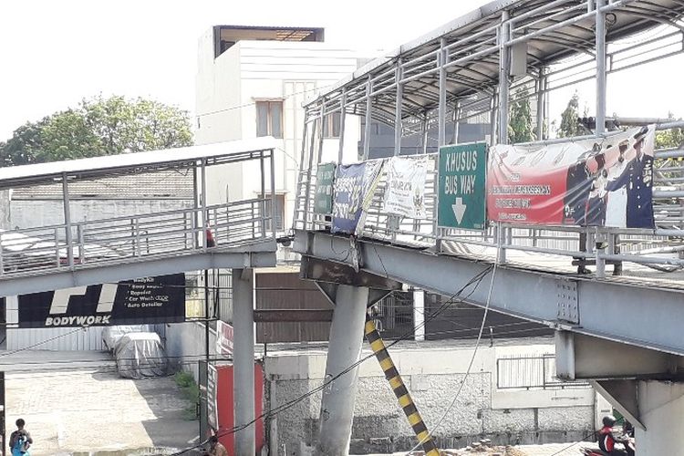 Kondisi JPO Dispenda Daan Mogot, Jakarta Barat yang miring akibat truk yang melaju dan tersangkut kabel di jembatan. Saat ini jembatan yang miring dan terputus sudah diganjal besi pengganjal pada Selasa (4/9/2018).