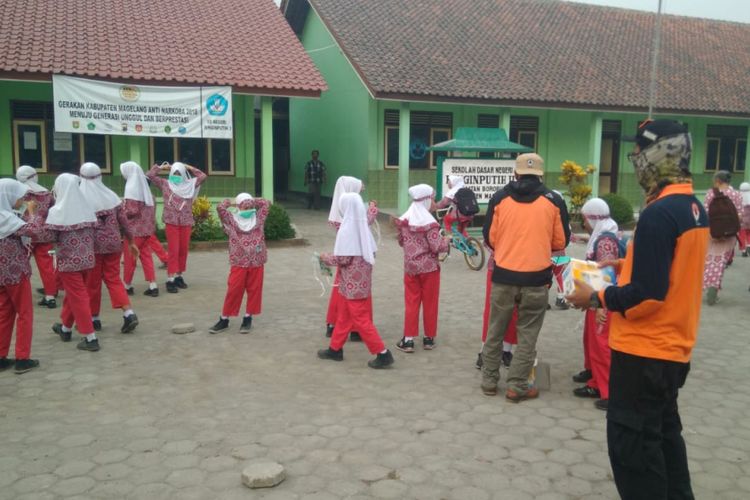 Petugas BPBD Kabupaten Magelang membagikan masker di sekolah-sekolah yang terdampak abu vulkanik Gunung Merapi, Kamis (24/5/2018) pagi.