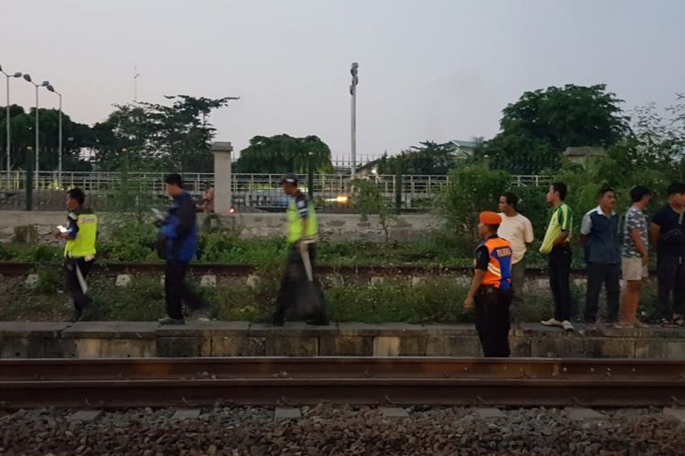 Petugas sedang melakukan penyisiran untuk mencari tubuh jenazah yang tertabrak kereta api, di perlintasan Cipinang, Pulo Gadung, Jakarta Timur, Kamis (25/10/2018)