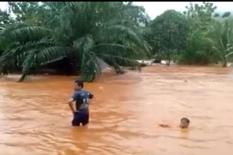 Warga korban banjir di Kabupaten Konawe Utara berusaha menyelamatkan barang-barang saat rumahnya hanyut terseret banjir. 