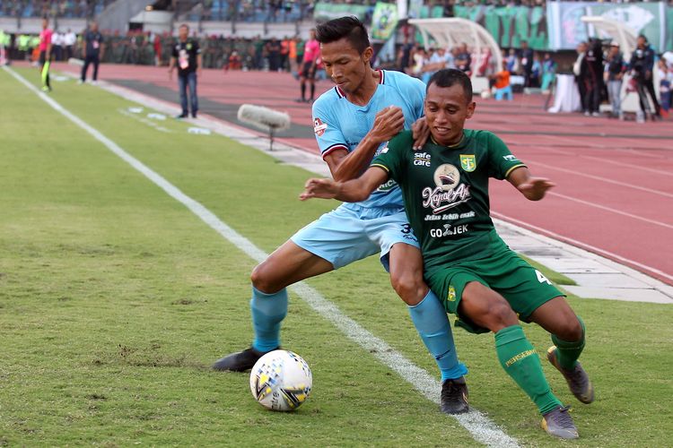 Pemain Persebaya Surabaya, Irfan Jaya (kanan) berebut bola dengan pemain Persela Lamongan, Eky Taufik pada Pekan ke 6 Liga 1 2019 yang berakhir dengan skor 3-2 di Stadion Gelora Bung Tomo, Surabaya, Jawa Timur, Senin (01/07/2019) sore.
