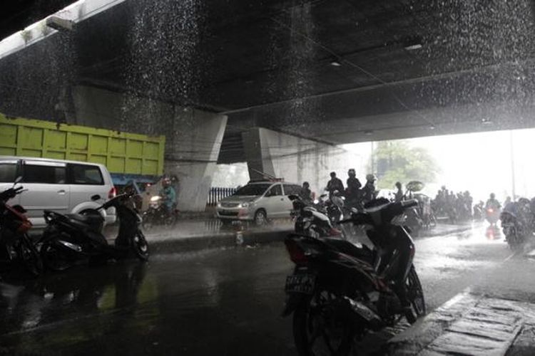 Pengendara motor berteduh di bawah jembatan di kawasan Slipi, Jakarta, Jumat (14/11/2014). Badan Meteorologi, Klimatologi, dan Geofisika (BMKG) memperkirakan wilayah DKI Jakarta diguyur hujan dengan intensitas ringan hingga sedang pada siang hingga malam hari. KOMPAS IMAGES/RODERICK ADRIAN MOZES