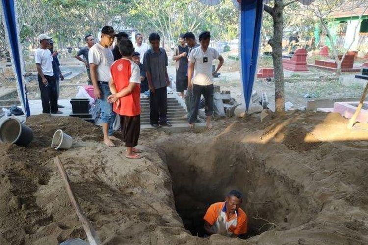 Tim penggali tengah menyiapkan pemakaman di TPU Sasonoloyo, Jalan Perintis Kemerdekaan, Kabupaten Boyolali, yang akan menjadi peristirahatan terakhir Sutopo Purwo, Senin (8/7/2019). 
