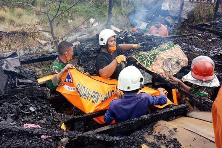 Petugas pemadam kebakaran dan prajurit TNI, mengevakuasi jenazah ibu dan anak yang meninggal dunia dalam insiden kebakaran di Gampong Kayee Lee, Kecamatan Ingin Jaya, Aceh Besar, Kamis (1/8/2019) pagi.
