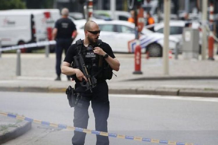 Seorang polisi bersenjata lengkap berjaga di sekitar lokasi penembakan di Liege, Belgia, yang menewaskan tiga orang Selasa (29/5/2018).