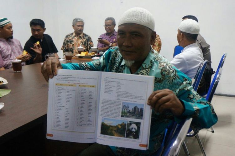 Seorang peserta audiensi menunjukkan buku IPS terpadu jilid 6A yang terdapat tulisan ibu kota negara yang salah di Solo, Jawa Tengah, Rabu (13/12/2017).