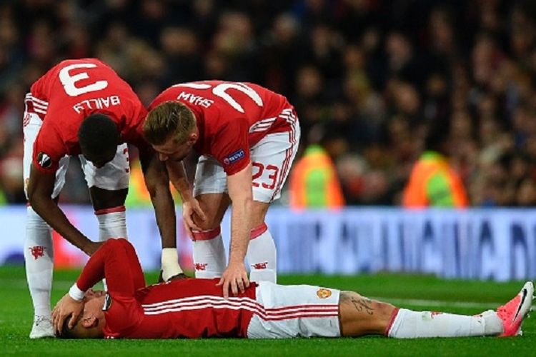 Eric Bailly dan Luke Shaw mencoba membantu Marcos Rojo yang mengerang kesakitan karena cedera saat membela Manchester United pada pertandingan Liga Europa kontra Anderlecht di Old Trafford, Kamis (20/4/2017). 