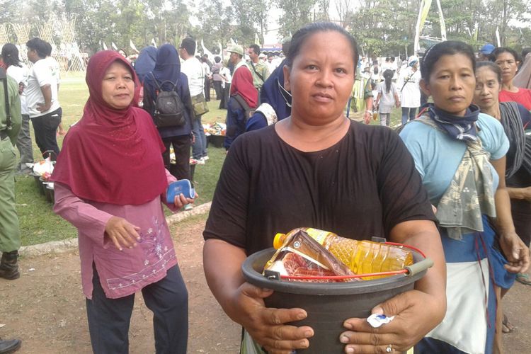 Warga Kalioso, Pariyati, menunjukkan paket sembako yang diberikan Solo Bersama Selamanya di Lapangan Kota Barat Solo, Jawa Tengah, Minggu (10/6/218).