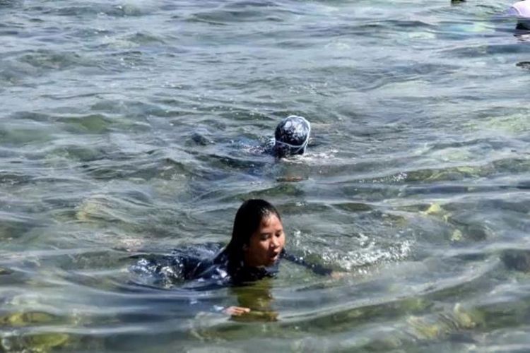 Polwan peserta berenang menyeberangi Selat Buton saat tiba di garis finish.