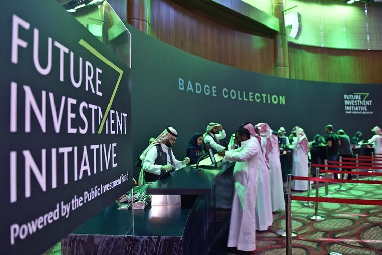 Dalam foto yang diambil pada 22 Oktober 2018 ini,  terlihat para jurnalis Arab Saudi mengambil tanda pengenal di pusat media KTT Inisiatif Investasi Masa Depan (FII) yang digelar 23-25 Oktober di Riyadh. 