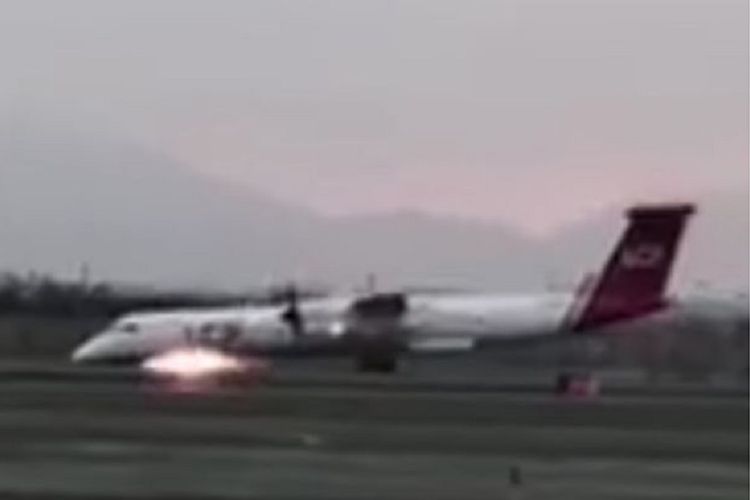 Foto yang diambil dari tangkapan layar video ini memperlihatkan saat-saat pesawat Bombardier Dash 8 milik maskapai penerbangan LC Peru mendarat darurat di bandara internasional Lima, Minggu (19/8/2018) tanpa roda depan sehingga memicu percikan api.