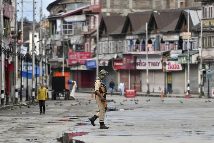 Seorang petugas keamanan berpatroli di Srinagar, Kashmir, yang sepi sejak diberlakukannya penguncian dan pembatasan berat.