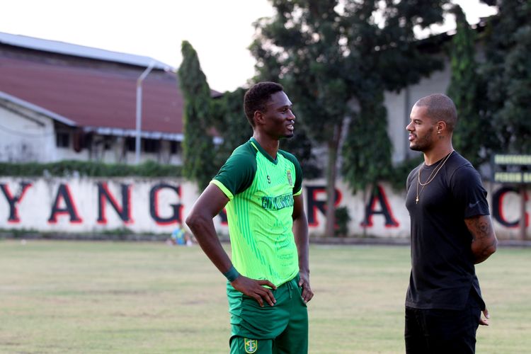Pemain asing Persebaya Surabaya, Amido Balde berbincang dengan permain baru David da Silva seusai latihan rutin di Lapangan Mapolda Jatim Surabaya, Rabu (24/07/2019) sore.