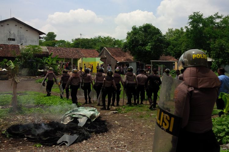 Personel polisi saat mengamankan jalannya pengosongan kampung Kentingan Baru, Kelurahan Jebres, Kecamatan Jebres, Solo, Jawa Tengah, Kamis (6/12/2018).