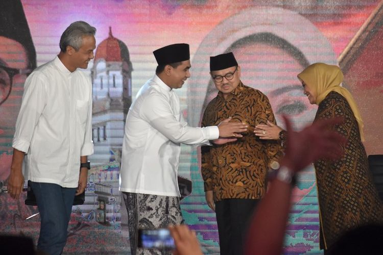 Calon gubernur Ganjar Pranowo (kiri) dan Sudirman Said (kedua kanan) menyaksikan calon wakil gubernur Taj Yasin (kedua kiri) dan Ida Fauziyah (kanan) berjabat tangan saat Debat Terbuka Pilkada Jawa Tengah di Ballroom Hotel Patra, Semarang, Jawa Tengah, Jumat (20/4/2018). 